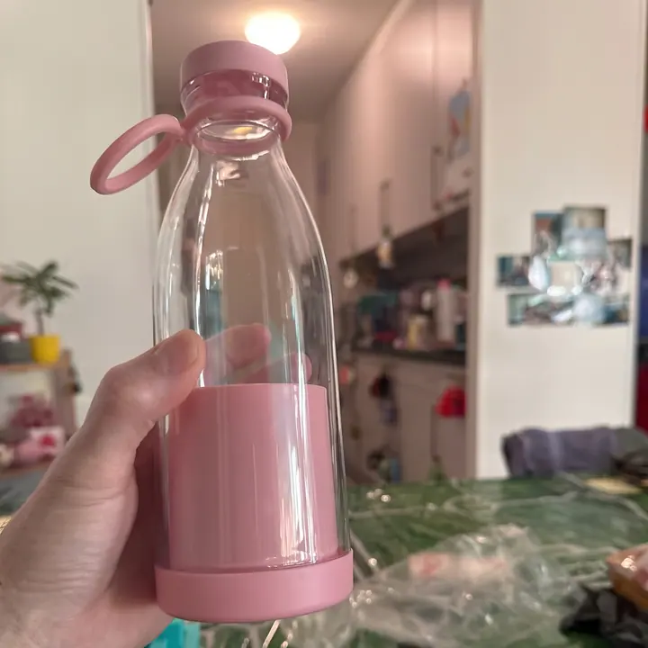 Licuadora portátil rosa sostenida en la mano